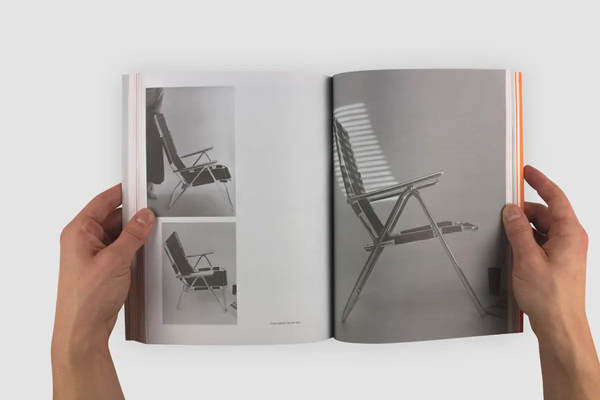 Livre ouvert, montrant trois photos monochromes d'une chaise pliable. 