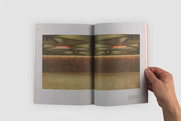Open book, showing a colour photo of Montreal metro station Place Saint-Henri. The photo is positioned in the center of the spread, across the center fold. 