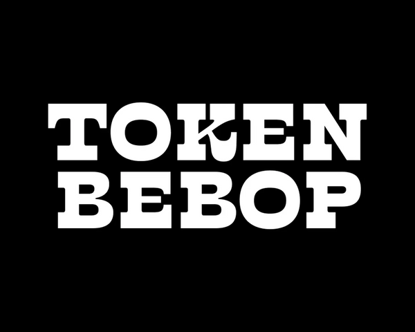 Token Bebop written in big white capital letters on a white background. The font is thick and curvy at the same time. The serifs are also thick like an egyptian, but the overall effect gives western vibes.